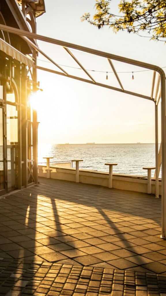 Terraço junto à água ao fim da tarde, banhado por luz dourada
